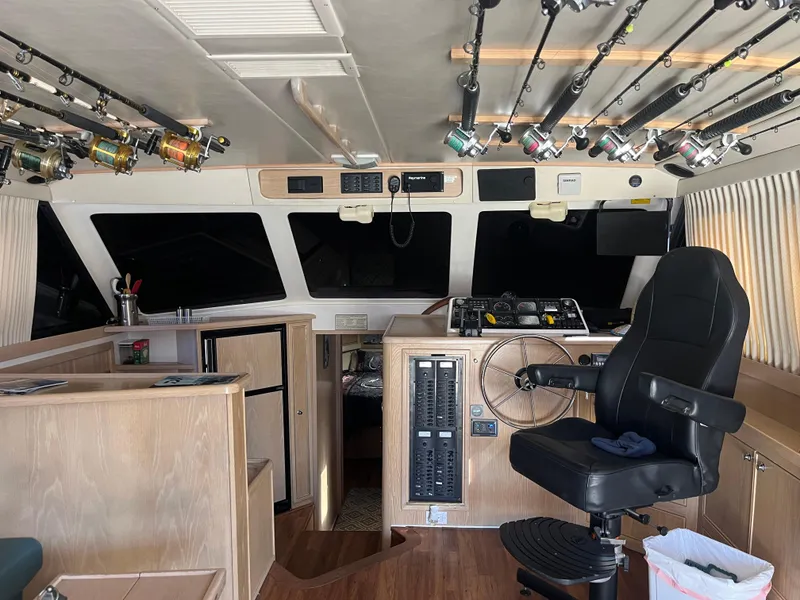 Slide: The Image of Das Bild zeigt das Cockpit einer Riviera 43 Open Flybridge von 1997 mit Angelruten an der Decke. - 31
