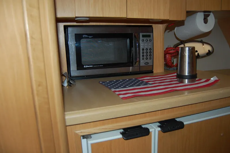 Slide: The Image of 2004 Tiara Yachts 3500 Open interior with microwave, American flag, and paper towel holder. - 12