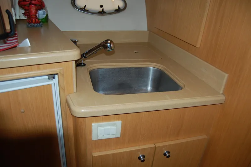 Slide: The Image of 2004 Tiara Yachts 3500 Open kitchen sink with wooden cabinetry and modern faucet. - 13