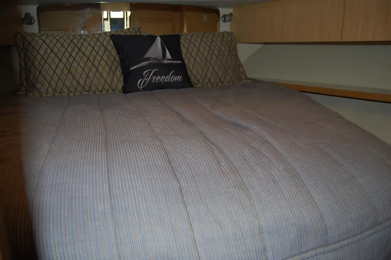 Slide: The Image of 2004 Tiara Yachts 3500 Open cabin with cozy bed and decorative pillows. - 15