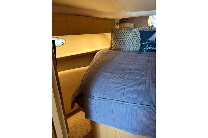 Slide: The Image of Cozy cabin interior of 2004 Tiara Yachts 3500 Open with plush bedding and pillows. - 16
