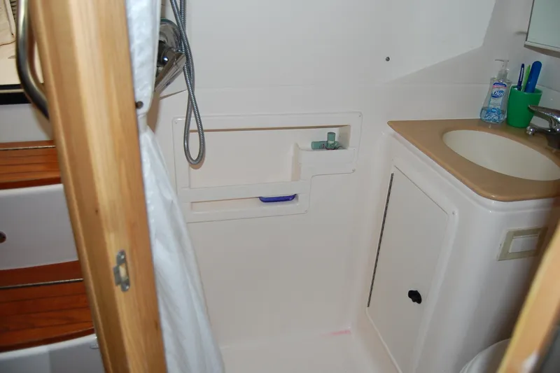 Slide: The Image of 2004 Tiara Yachts 3500 Open bathroom with sink, shower, and storage shelves. - 17