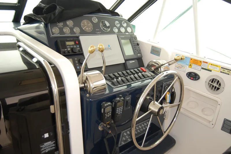 Slide: The Image of 2004 Tiara Yachts 3500 Open helm with steering wheel and navigation controls. - 5