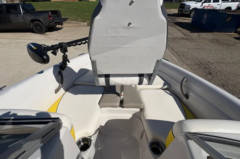 Slide: The Image of 2005 Tahoe Q4 SF boat interior with seating and motor, parked outdoors. - 11