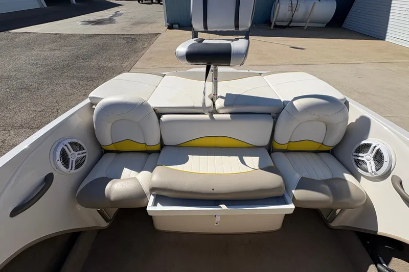 Slide: The Image of 2005 Tahoe Q4 SF boat interior with white and yellow seating, speakers, and storage compartment. - 20