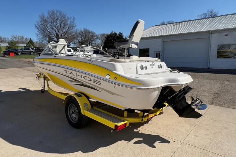 Slide: The Image of 2005 Tahoe Q4 SF boat on trailer, yellow and white design, parked outdoors. - 3