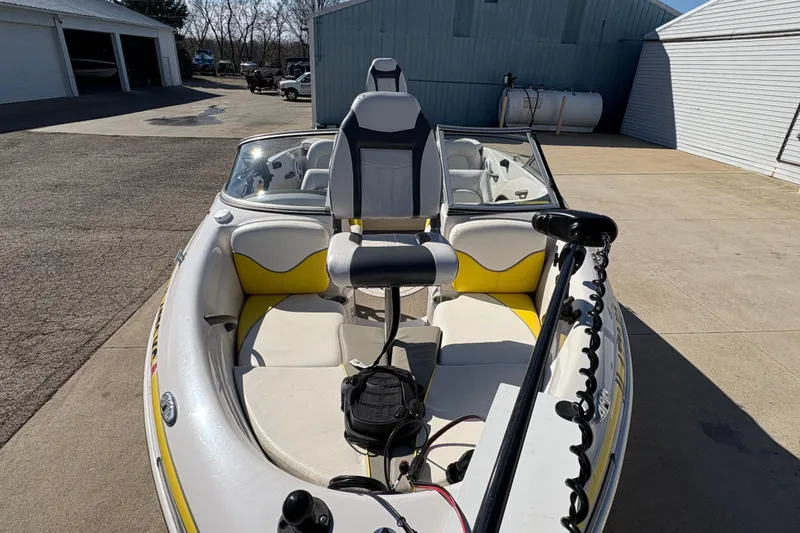 Slide: The Image of 2005 Tahoe Q4 SF boat with seating and trolling motor in a driveway. - 8