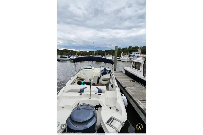 Slide: The Image of 2013 Stingray 234 LR boat docked at marina under cloudy sky. - 11