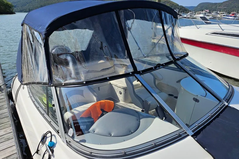 Slide: The Image of 2013 Stingray 234 LR boat with canopy docked by the water. - 3