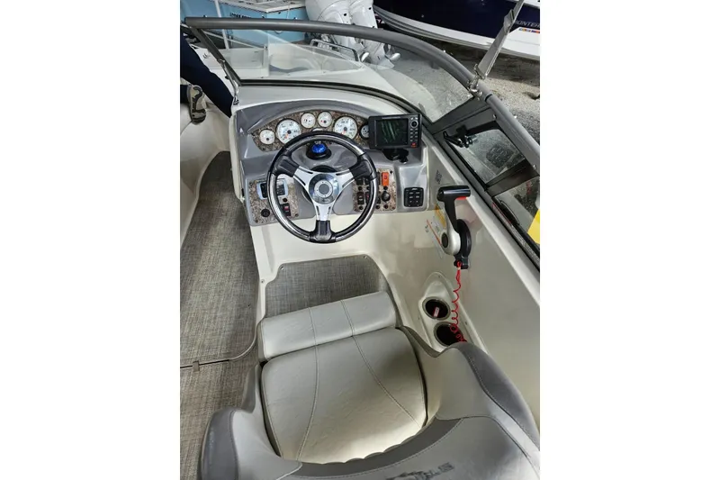 Slide: The Image of 2013 Stingray 234 LR boat cockpit with steering wheel and control panel. - 6