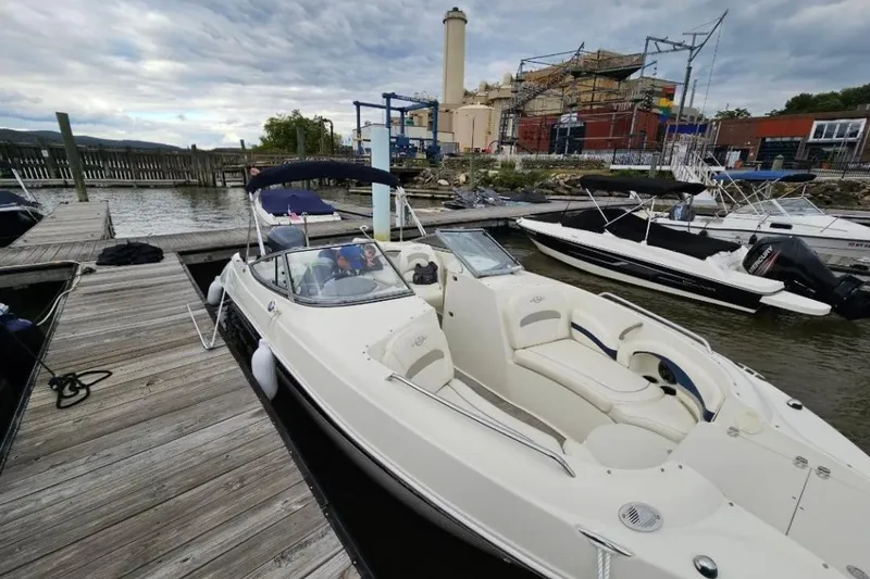 Slide: The Image of 2013 Stingray 234 LR boat docked at a marina with overcast skies. - 7