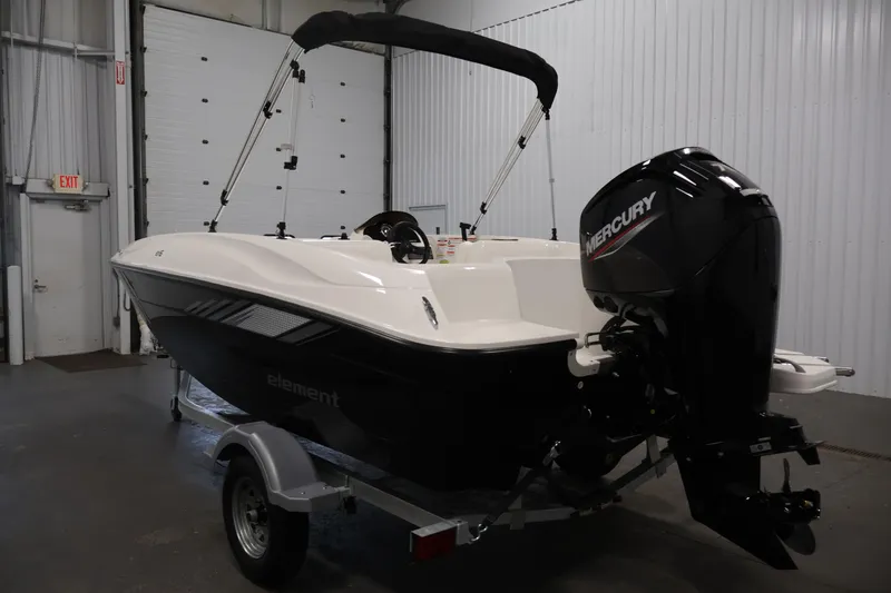 Slide: The Image of 2026 Bayliner Element E16 boat with Mercury outboard motor in a garage setting. - 13