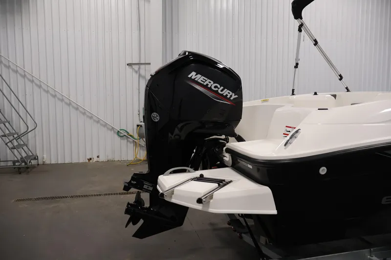 Slide: The Image of 2026 Bayliner Element E16 boat with Mercury outboard motor in a garage setting. - 40