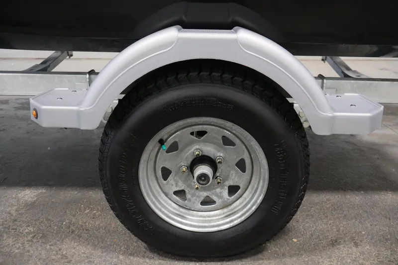 Slide: The Image of Trailer wheel and fender of 2026 Bayliner Element E16 boat on concrete surface. - 45