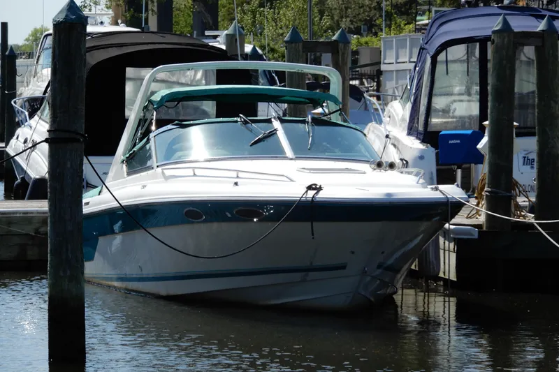 The Image of 1994 Sea Ray 310 Sun Sport docked at a marina, surrounded by other boats. - 0