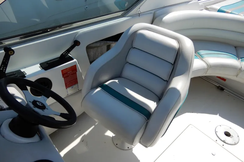 Slide: The Image of 1994 Sea Ray 310 Sun Sport boat interior with steering wheel and cushioned seating. - 11
