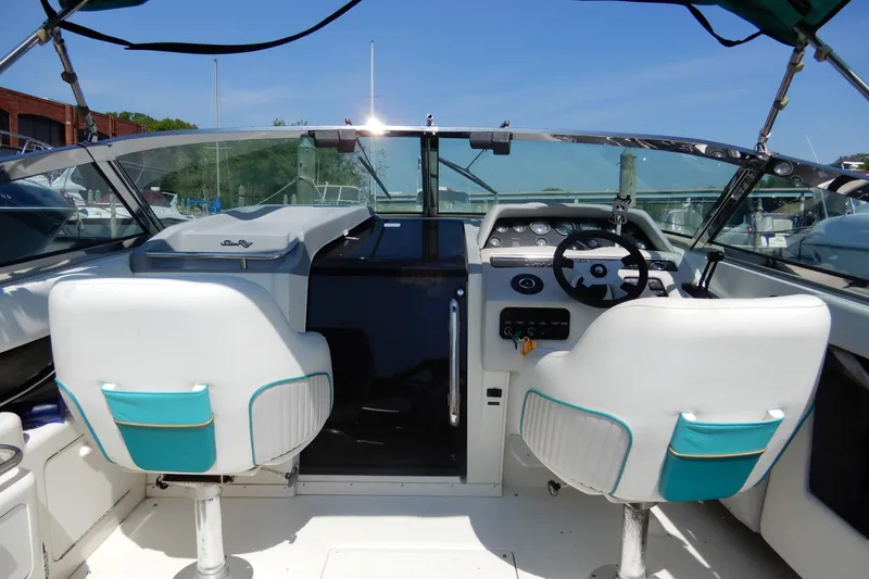 Slide: The Image of 1994 Sea Ray 310 Sun Sport boat cockpit with white and teal seating, steering wheel, and dashboard. - 12