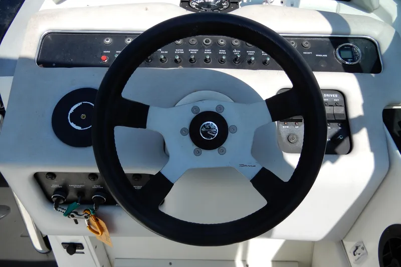 Slide: The Image of Steering wheel and controls of a 1994 Sea Ray 310 Sun Sport boat. - 17