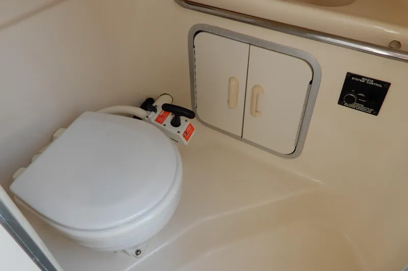 Slide: The Image of 1994 Sea Ray 310 Sun Sport boat bathroom with toilet and storage cabinet. - 32