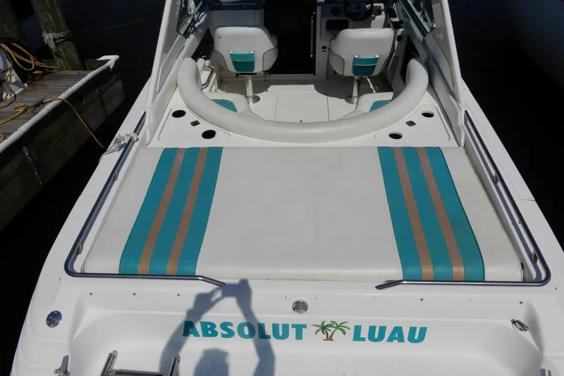 Slide: The Image of 1994 Sea Ray 310 Sun Sport boat with teal and beige striped seating, docked at marina. - 5
