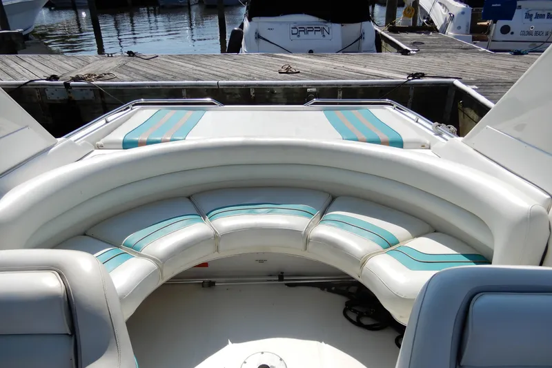 Slide: The Image of 1994 Sea Ray 310 Sun Sport boat with white and teal seating at a marina. - 6
