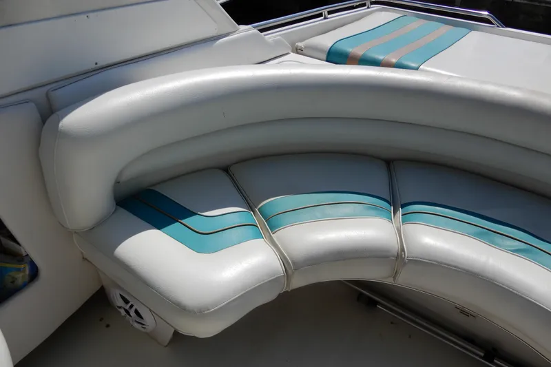 Slide: The Image of Curved seating on 1994 Sea Ray 310 Sun Sport boat with teal accents. - 7