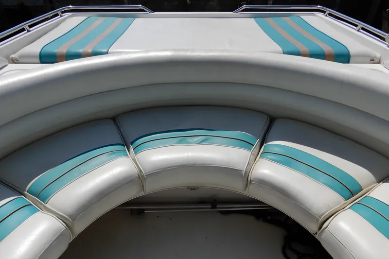 Slide: The Image of Curved seating on 1994 Sea Ray 310 Sun Sport boat with teal and beige accents. - 8