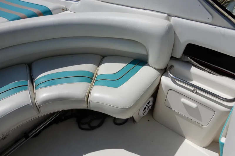 Slide: The Image of 1994 Sea Ray 310 Sun Sport boat interior with curved seating and teal accents. - 9
