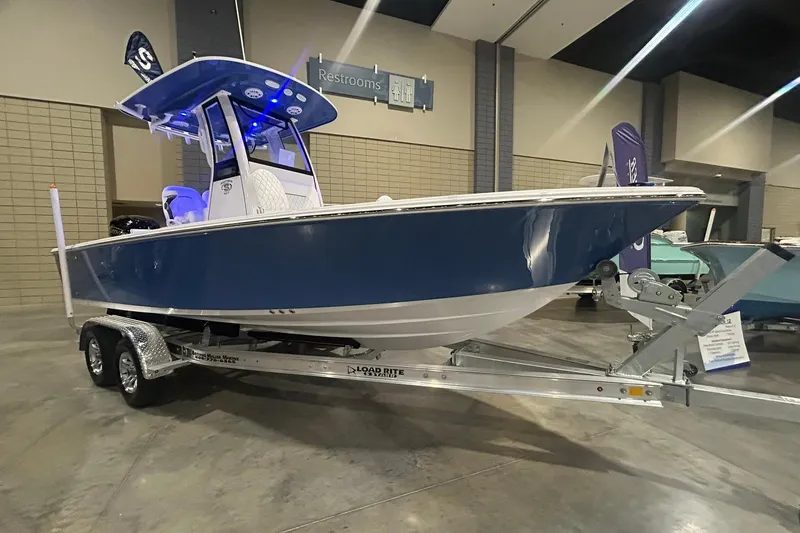 The Image of 2026 Sportsman Masters 227 Bay Boat displayed indoors on a trailer. - 1