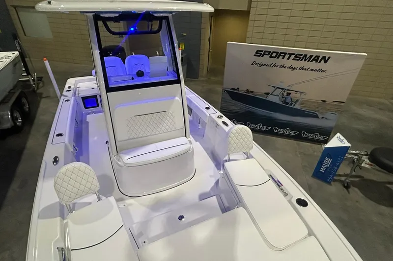 Slide: The Image of 2026 Sportsman Masters 227 Bay Boat displayed indoors with promotional banner. - 2