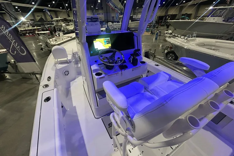 Slide: The Image of 2026 Sportsman Masters 227 Bay Boat interior with modern helm and seating at a boat show. - 6