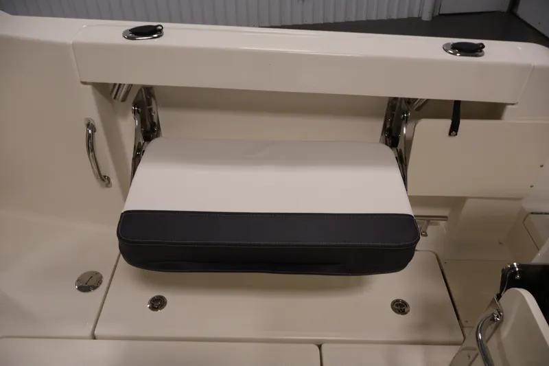 Slide: The Image of 2026 Bayliner Trophy T23 Pilothouse interior seating detail, featuring foldable cushioned seat. - 42