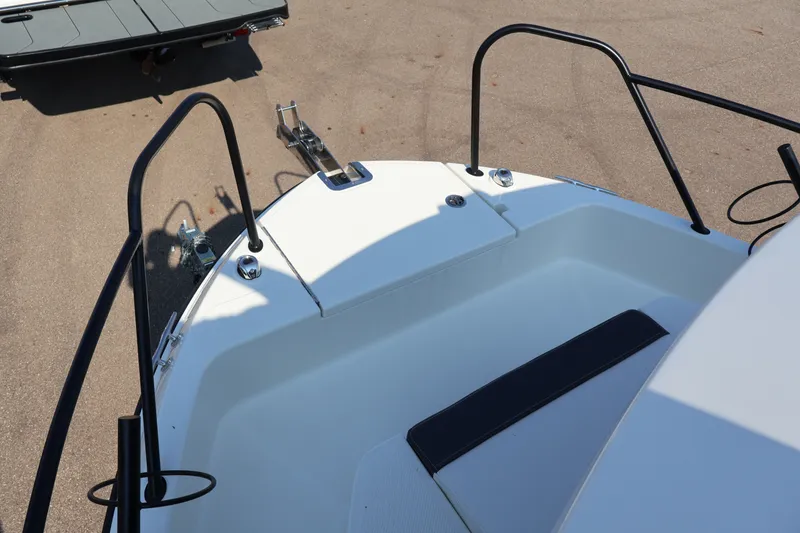 Slide: The Image of 2026 Bayliner Trophy T23 Pilothouse boat bow with trailer in background. - 69