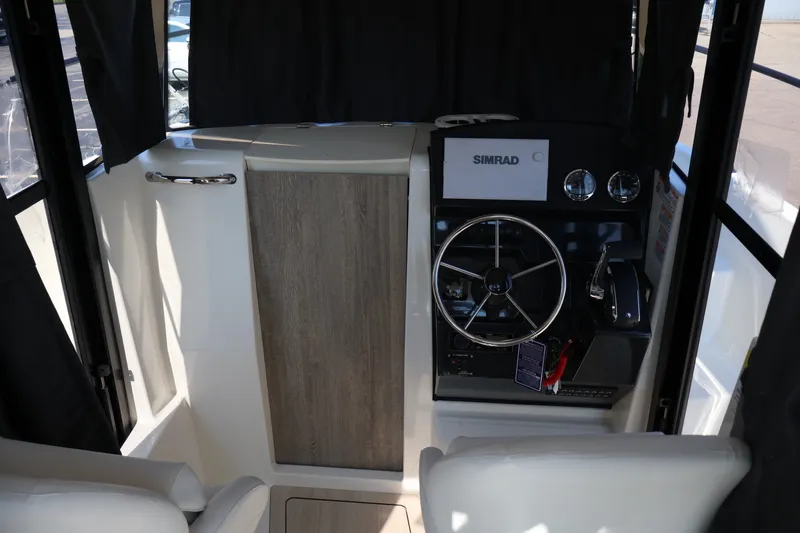 Slide: The Image of 2026 Bayliner Trophy T23 Pilothouse interior with steering wheel and Simrad navigation system. - 66