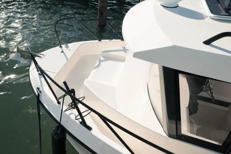 Slide: The Image of 2026 Bayliner Trophy T23 Pilothouse boat docked, showcasing sleek design and pilothouse features. - 2