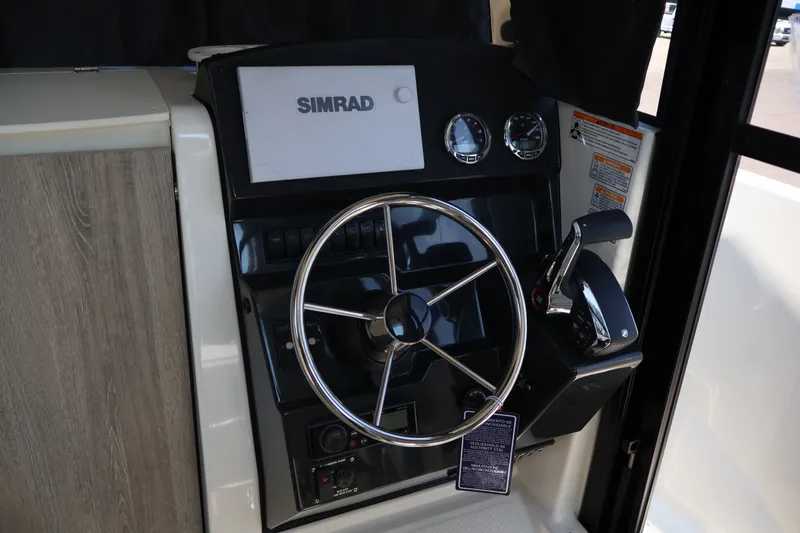 Slide: The Image of 2026 Bayliner Trophy T23 Pilothouse helm with Simrad display and steering wheel. - 67