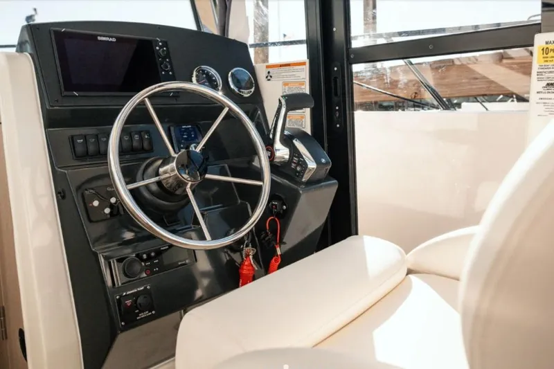 Slide: The Image of Pilothouse interior of 2026 Bayliner Trophy T23, featuring steering wheel and control panel. - 4