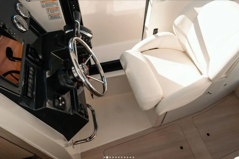 Slide: The Image of Interior helm of 2026 Bayliner Trophy T23 Pilothouse with steering wheel and captain's chair. - 5