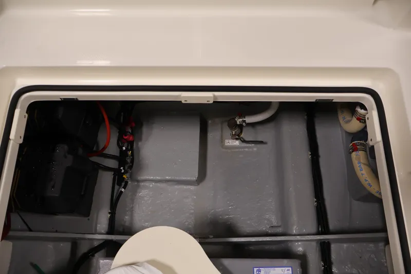 Slide: The Image of 2026 Bayliner Trophy T23 Pilothouse engine compartment with battery and hoses visible. - 40