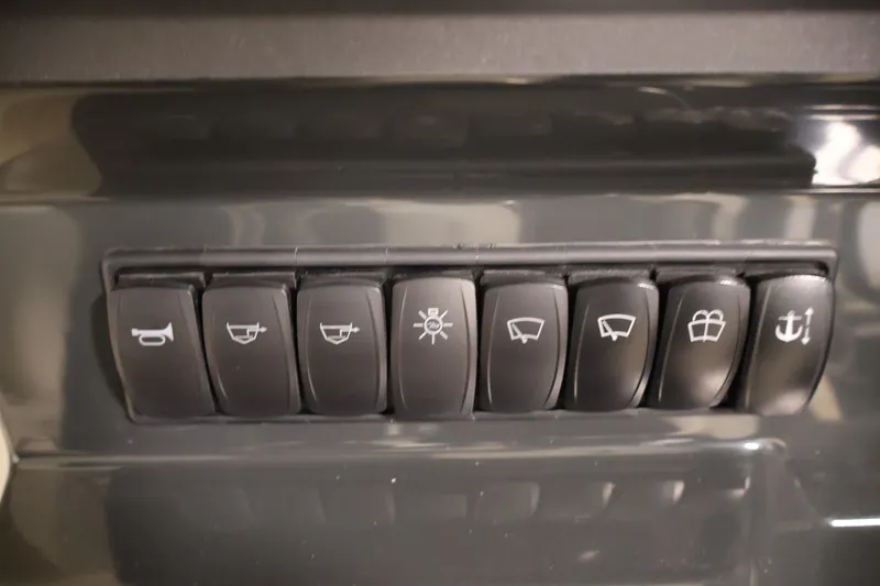 Slide: The Image of Control panel switches on a 2026 Bayliner Trophy T23 Pilothouse boat dashboard. - 24