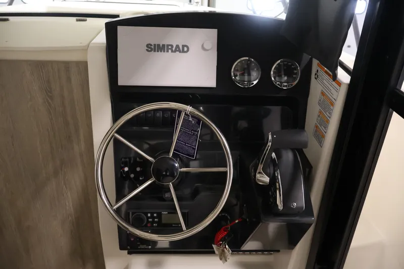 Slide: The Image of 2026 Bayliner Trophy T23 Pilothouse helm with Simrad display and steering wheel. - 20