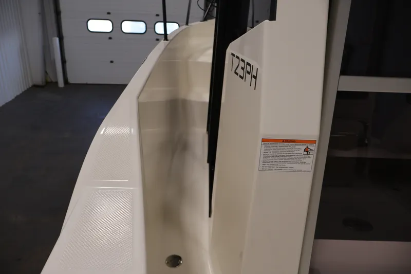 Slide: The Image of 2026 Bayliner Trophy T23 Pilothouse boat interior detail in a garage setting. - 17