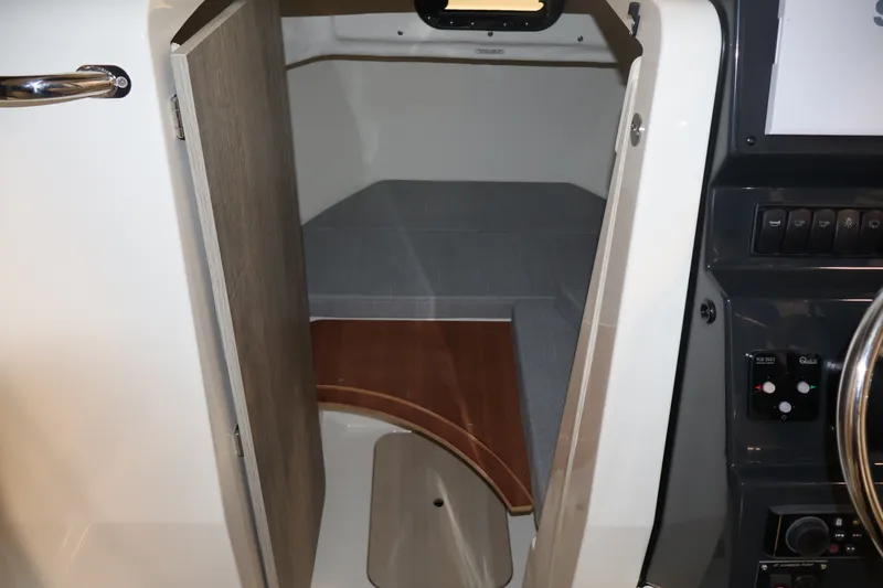 Slide: The Image of 2026 Bayliner Trophy T23 Pilothouse cabin interior with open door and control panel. - 38