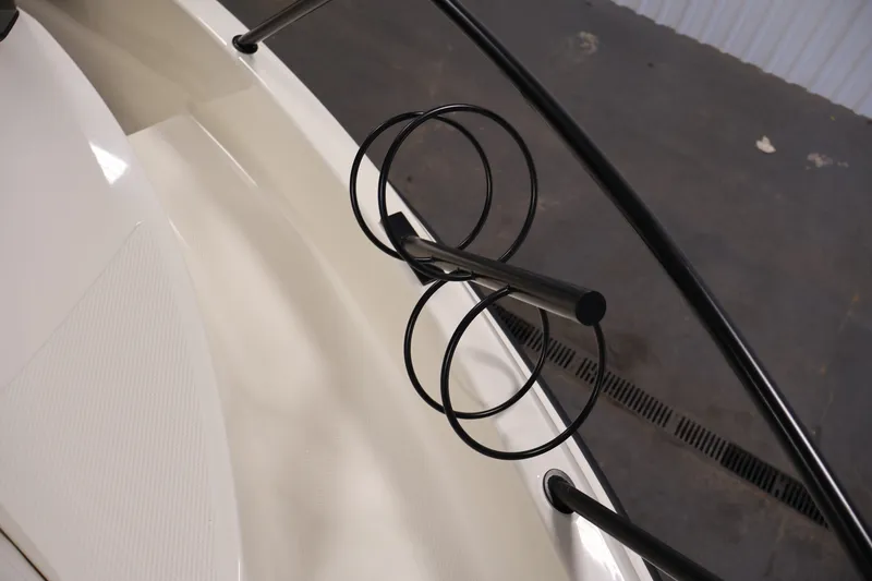 Slide: The Image of Bayliner Trophy T23 Pilothouse 2026 boat deck with black railings and rod holders. - 15