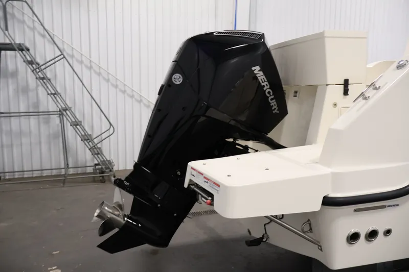 Slide: The Image of 2026 Bayliner Trophy T23 Pilothouse with Mercury outboard motor in a storage facility. - 56