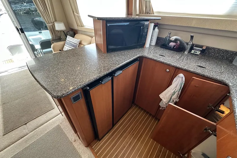 Slide: The Image of Interior of 2003 Meridian 381 Sedan yacht kitchen with granite countertops and wooden cabinets. - 23