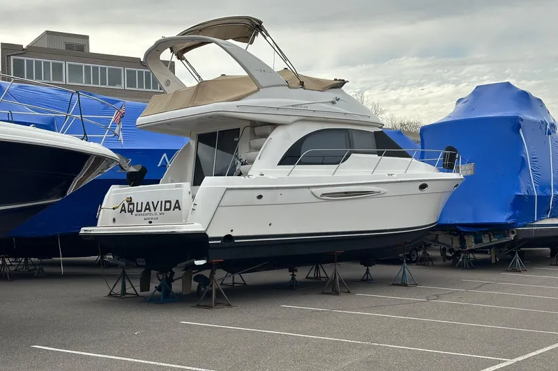 Slide: The Image of 2003 Meridian 381 Sedan yacht on stands, named "Aquavida," in a marina parking lot. - 5