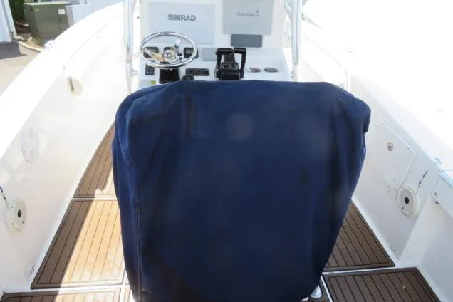 Slide: The Image of 2006 Sea Hunt Triton 260 boat interior with covered helm and wooden deck. - 10