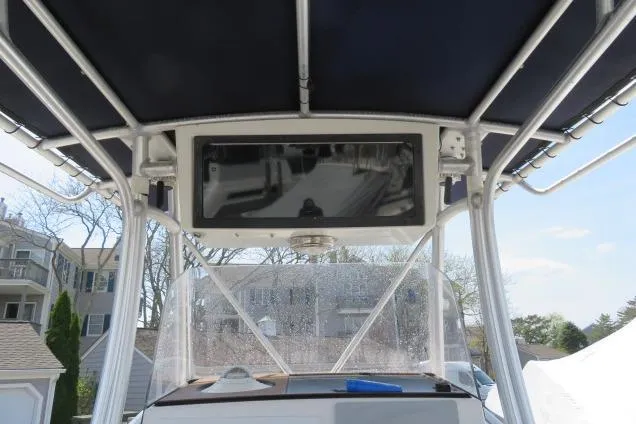 Slide: The Image of 2006 Sea Hunt Triton 260 boat with T-top and console, parked outdoors. - 12