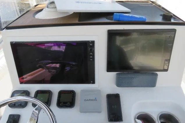 Slide: The Image of 2006 Sea Hunt Triton 260 dashboard with navigation screens and controls. - 17